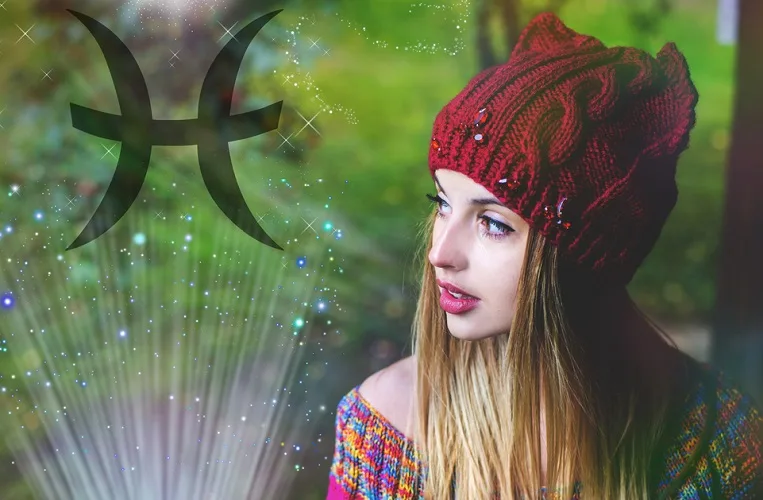 Woman with a red hat and colorful top with a magical looking background and the Pisces zodiac sign on the left